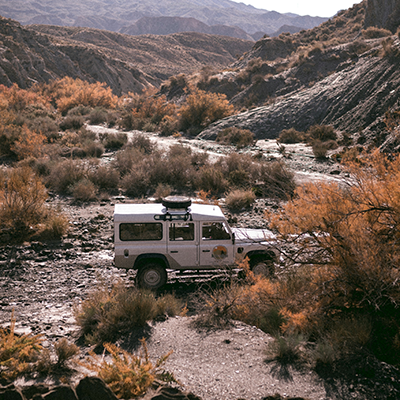 Land Rover Defender navigating rugged terrain serviced by Bentley Auto Centre