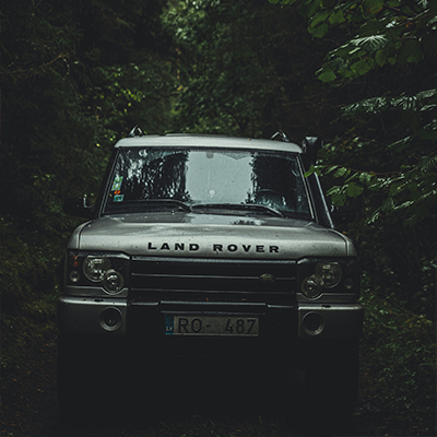 Land Rover Discovery navigating through a dense forest serviced by Bentley Auto Centre